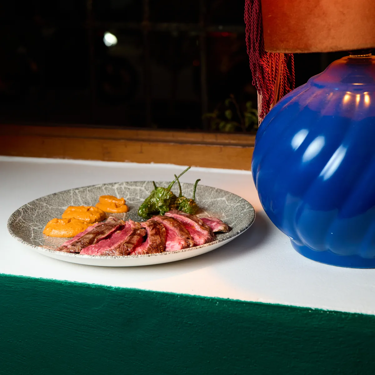 Entraña a la brasa con salsa romesco y pimientos de Padrón