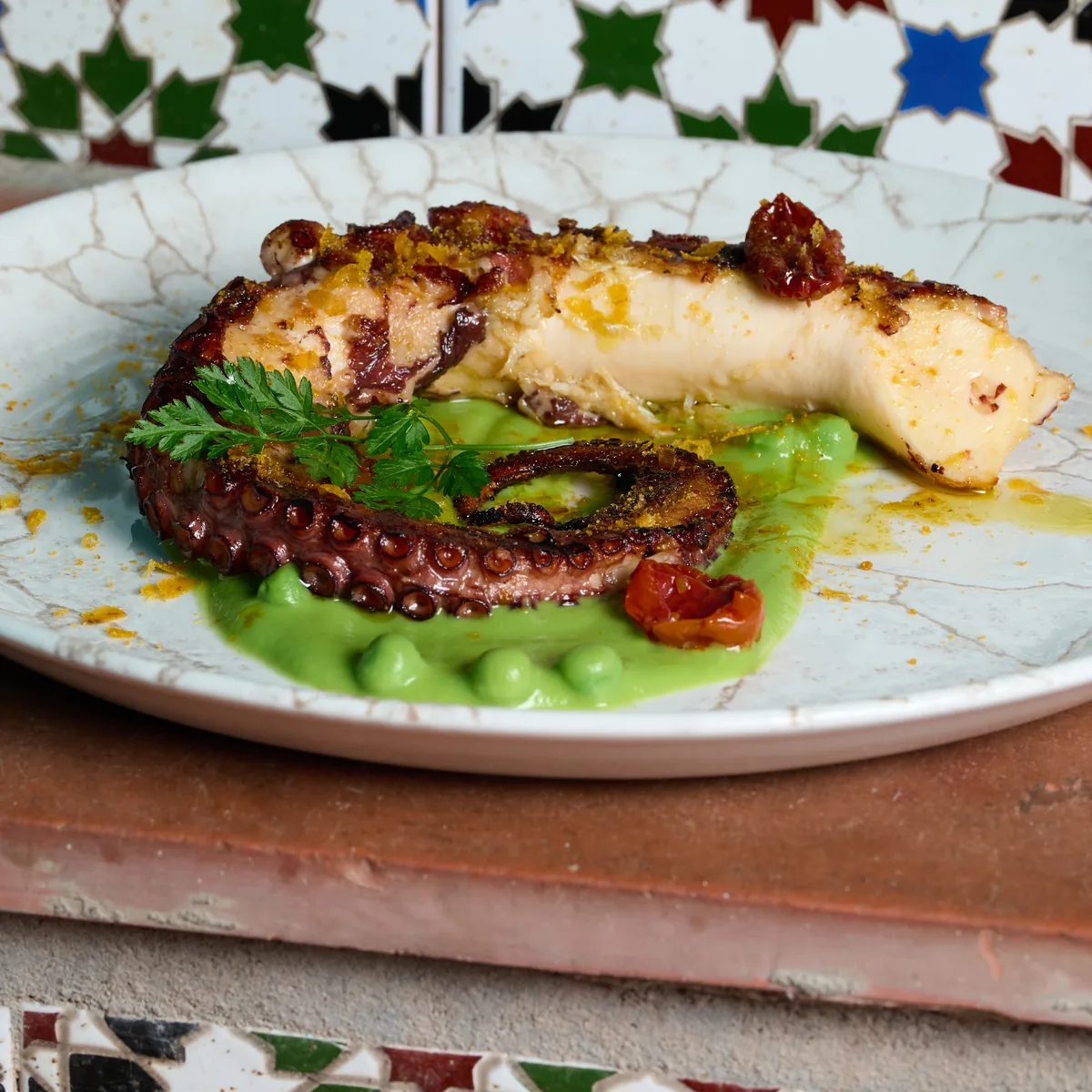 Pulpo a la brasa con crema de guisantes y bottarga